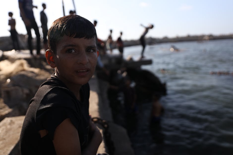 Palestinian children waiting near empty food aid crates